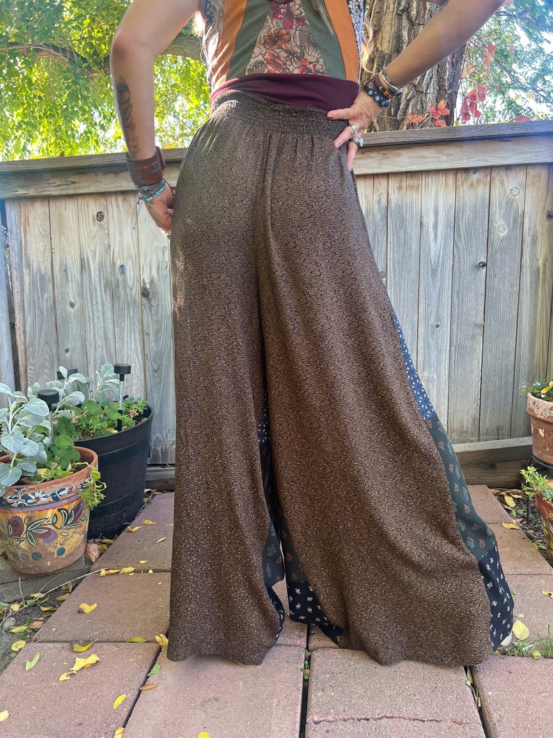 May include: Wide-leg pants with a brown and black patterned fabric. The pants have a high waist and a relaxed fit. The fabric has a subtle shimmer.