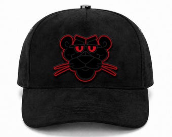 May include: A black baseball cap with a textured suede-like finish featuring a centered graphic of a stylized panther head. The panther design is outlined in vibrant red with matching red eyes and whiskers, creating a bold contrast against the black fabric.