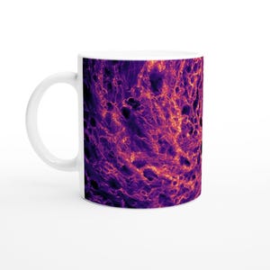 May include: White ceramic mug with a striking abstract design in purple, orange, and black. The pattern evokes a fiery, textured landscape. The mug has a standard handle and a glossy finish.