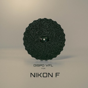 May include: A dark green, circular camera accessory with a textured surface. The product has a small square opening in the centre. The text "DISPO VFL for NIKON F" is printed below the accessory.