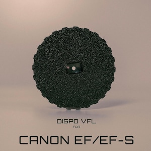 May include: A black, textured, circular camera accessory with a small, rectangular attachment in the centre. The text "DISPO VFL FOR CANON EF/EF-S" is printed below the accessory.