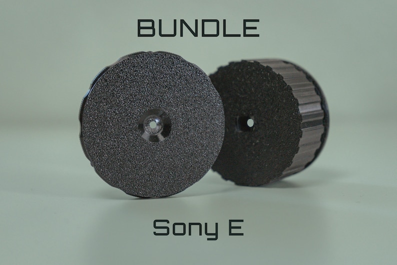 Op de afbeelding: Twee donkergrijze, cirkelvormige objecten met een textuur en een centraal gat. Het woord "BUNDLE" staat bovenaan en "Sony E" onderaan. De objecten lijken componenten of accessoires te zijn.