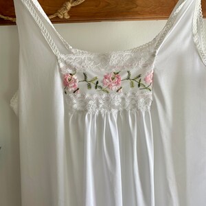 Puede incluir: Camis&oacute;n blanco de algod&oacute;n con delicado encaje y flores rosas bordadas.