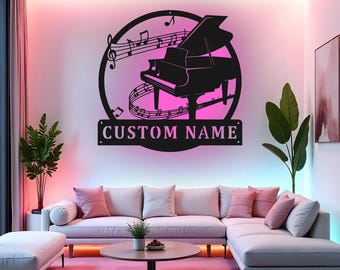 Può includere: Arte da parete con pianoforte in metallo nero con note musicali e la scritta "CUSTOM NAME". Il pianoforte è posto su uno sfondo rosa, in un moderno soggiorno.