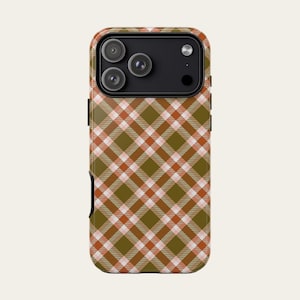 Puede incluir: Una funda para smartphone con un patrón de cuadros en diagonal en tonos verde oliva, naranja quemado y blanco. La funda tiene un módulo de cámara negro en la parte superior con tres aberturas circulares y un flash circular.