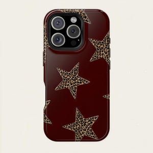 May include: A burgundy phone case featuring a pattern of leopard print stars. The case has a glossy finish and a dark burgundy border. The camera lenses are visible at the top of the case.