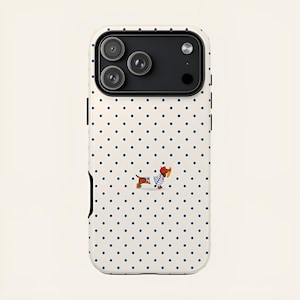 May include: A white iPhone case with a pattern of navy blue polka dots. The case features a cartoon dachshund wearing a striped shirt and a red beret. The phone case has a black camera module.