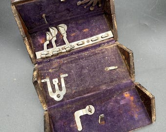 vintage Singer oak sewing machine "puzzle box" containing various metal attachments.