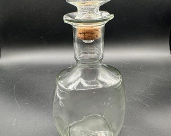 vintage clear glass liquor decanter with a cork and glass stopper