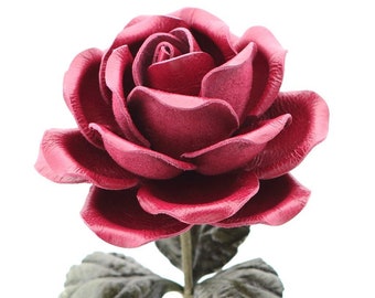 May include: A single, deep red leather rose with green leaves. The rose is crafted from leather and has a realistic appearance.