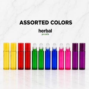 May include: A set of twelve cylindrical glass roller bottles with matching caps, arranged in a row. The bottles feature a rainbow of translucent colors including yellow, red, green, blue, pink, and purple. Text reads ASSORTED COLORS herbal prods.