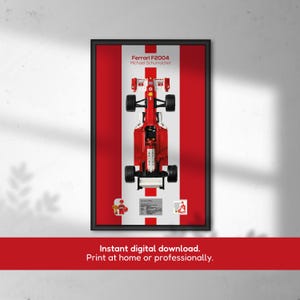 Può includere: Stampa incorniciata di una Ferrari F2004 rossa su sfondo a strisce rosse e bianche. Il testo "Ferrari F2004 Michael Schumacher" è in alto. Il testo in basso recita "Download digitale istantaneo. Stampa a casa o professionalmente."