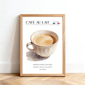 May include: A framed print featuring a watercolor illustration of a cup of café au lait. The print includes the text "CAFÉ AU LAIT" and "EST. 1800s" with the French flag. Additional text describes the drink as brewed coffee with hot milk, smooth, milky, and balanced, with a volume of 240-300 mL.