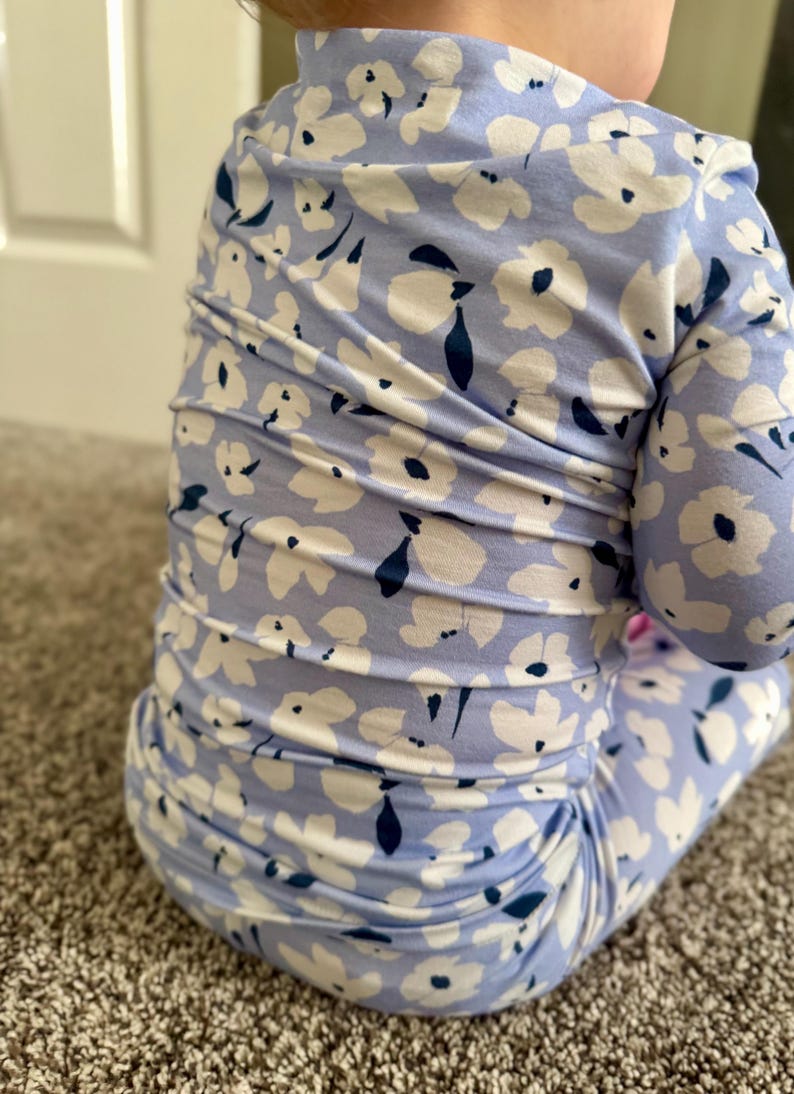 Blue floral bamboo baby pajama with soft white flower print, long-sleeve zip-up one-piece featuring fold-over mittens and feet, a tagless neckline for sensitive skin, and a convenient 2-way zipper—comfortable, breathable infant sleeper for girls. two piece toddler set for sleeps wear. super soft and breathable
