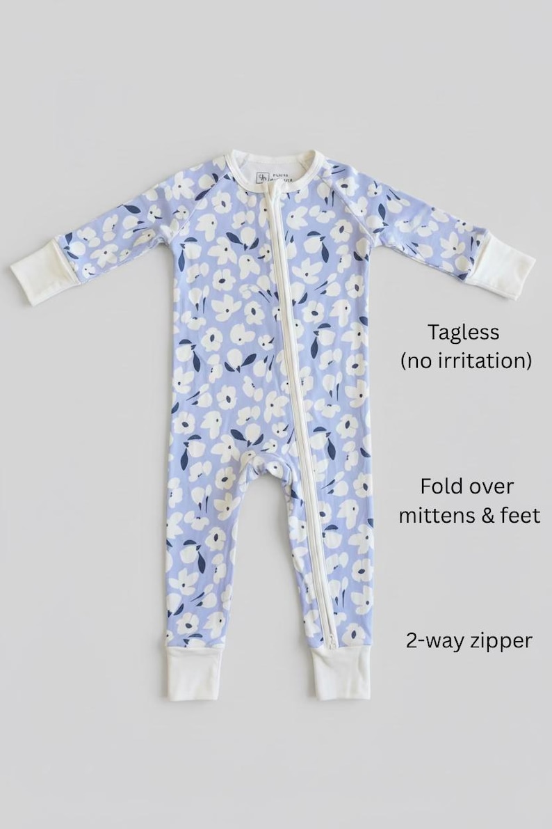Blue floral bamboo baby pajama with soft white flower print, long-sleeve zip-up one-piece featuring fold-over mittens and feet, a tagless neckline for sensitive skin, and a convenient 2-way zipper—comfortable, breathable infant sleeper for girls.