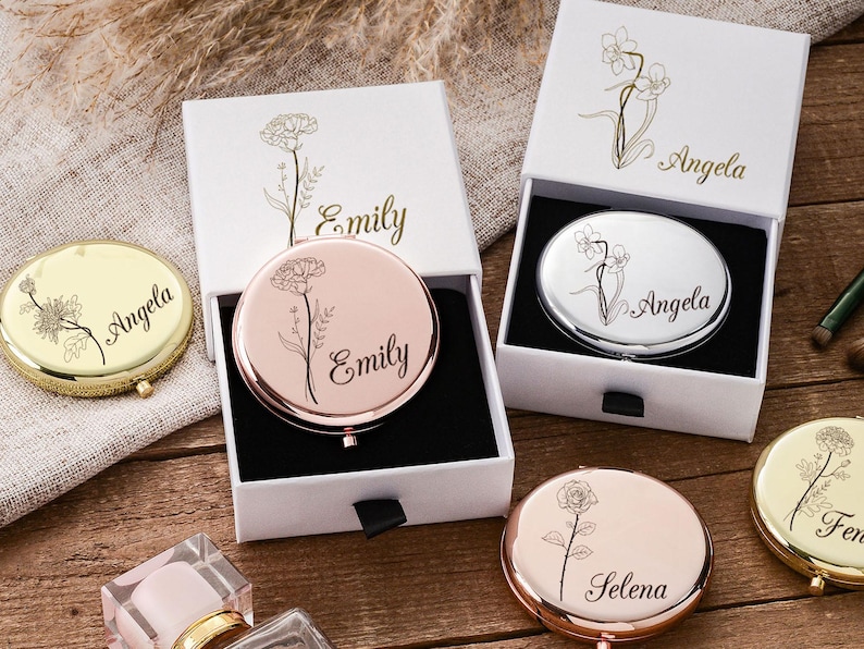 May include: Compact mirrors in gold, rose gold, and silver, each with a floral design and personalized name. The mirrors are in white boxes with matching floral accents. A stylish and personalized gift.