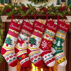 Peut inclure: Cinq chaussettes de Noël en tricot suspendues en rangée, chacune avec un revers rouge brodé des prénoms Sarah, Janice, Emily, Rachel et Austin. Les chaussettes présentent des motifs festifs incluant des sapins, des rennes et des flocons.
