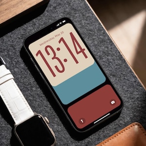 May include: A smartphone displaying a digital clock interface with the text Wednesday, May 20 and the time 13:14 in large red numerals. The screen features a color-blocked design with beige, blue, and dark red sections, alongside a camera and flashlight icon.