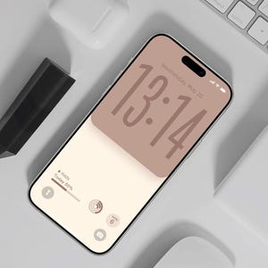 May include: A smartphone displaying a digital clock interface with the time 13:14, the date Wednesday, May 20, and weather information indicating rain and 50% probability. The screen features a minimalist aesthetic with soft beige and brown tones.