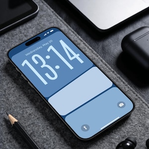 May include: A smartphone with a blue and white screen displaying the time 13:14 and the date Wednesday, May 20. The phone is on a gray surface with a pencil, laptop, tablet, and wireless earbuds. The text "@ Design by DreamScreenz" is at the bottom.