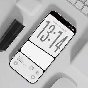May include: A smartphone screen shows the time 13:14 and the date Wednesday, May 20. The phone is next to a white keyboard, wireless earbuds, and a black rectangular object. The design is minimalist and modern, with a clean aesthetic.