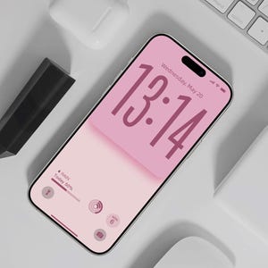 Può includere: Uno smartphone argentato mostra uno schermo rosa con l'ora 13:14 e la data mercoledì 20 maggio. Sono visibili anche una tastiera bianca, auricolari wireless e uno stilo nero. Lo schermo mostra un'icona meteo che indica il 50% di probabilità di pioggia.