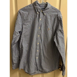 Op de afbeelding: Een overhemd met lange mouwen in een marineblauw en wit ruitpatroon. Het overhemd heeft een button-down kraag, een klein geborduurd logo op de borst en hangt aan een hanger.