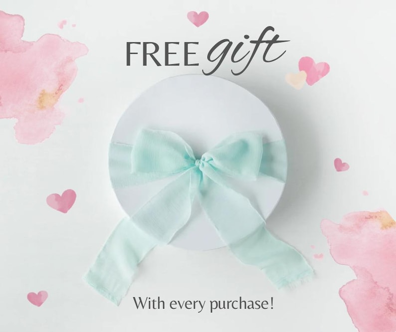 May include: A white round gift box with a light blue ribbon bow. The words "FREE gift" are above the box, and "With every purchase!" is below. Pink watercolor hearts and splashes decorate the white background.