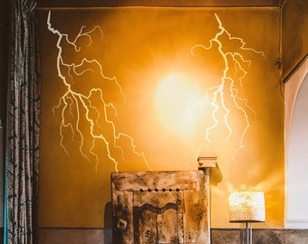 May include: A yellow couch with a wooden door behind it. The couch has three pillows, one with a red and white pattern, one with a blue and white pattern, and one with a white and black pattern. The wall behind the couch is painted yellow and has a white lightning bolt design.