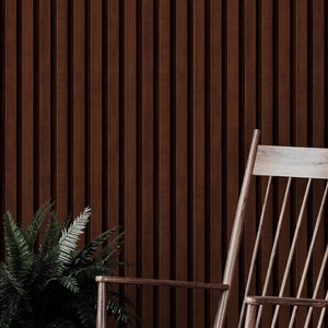 May include: A wooden rocking chair with a slatted back and seat. The chair is in front of a wall with vertical wooden panels.