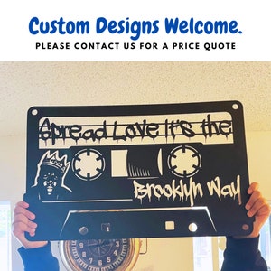 May include: Black metal cassette tape wall art with the text "Spread Love It's the Brooklyn Way".