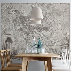 May include: A vintage map of Rome printed on a wall mural, with a wooden dining table and chairs in front of it. The table is set with glass bottles and a plant.