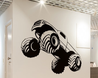 May include: Black and white silhouette of a monster truck with large tires, jumping in the air. The truck is facing the right side of the image.