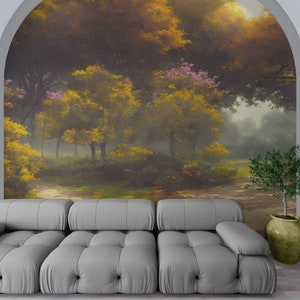 Pode incluir: Um sof&aacute; capiton&ecirc; cinza-claro est&aacute; posicionado em frente a um grande mural de parede arqueado que retrata uma cena de floresta com &aacute;rvores amarelo-douradas, folhagem verde e luz suave. Uma pequena planta verde num vaso bege arredondado.