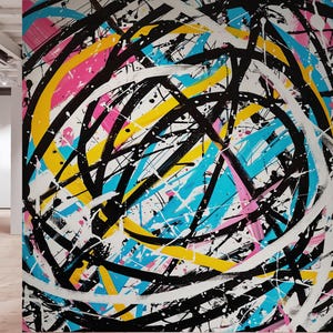May include: Abstract artwork featuring a dynamic composition of black, white, yellow, pink, and blue brushstrokes. The design includes overlapping lines and splatters, creating a sense of movement and energy. The artwork is on a white background.