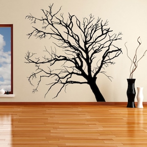May include: A black silhouette of a bare tree branch with a few small white objects on a window sill in the background.