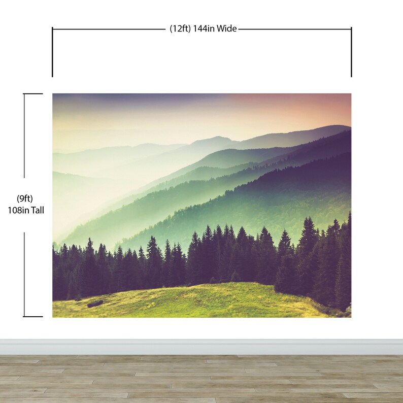 May include: A wall mural featuring a mountain landscape with a foreground of green grass and dark pine trees, fading into misty blue ridges under a soft sunset sky. The mural measures 144 inches wide by 108 inches tall as indicated by the labels.