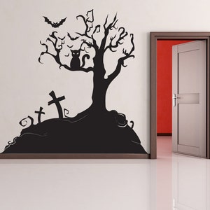May include: Black and white Halloween wall decal featuring a spooky tree with bats, a cat, and three tombstones. The decal is applied to a white wall with a door in the background.