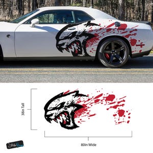 May include: White car with a black and red graphic of a snarling animal head on the side. The graphic is 80 inches wide and 38 inches tall. The car has black wheels and red brake calipers.
