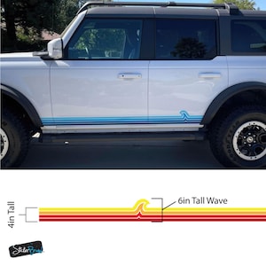May include: White SUV with a blue wave design sticker. The sticker features a series of horizontal lines in shades of blue, with a wave graphic. The wave is 6 inches tall. The sticker is 4 inches tall.