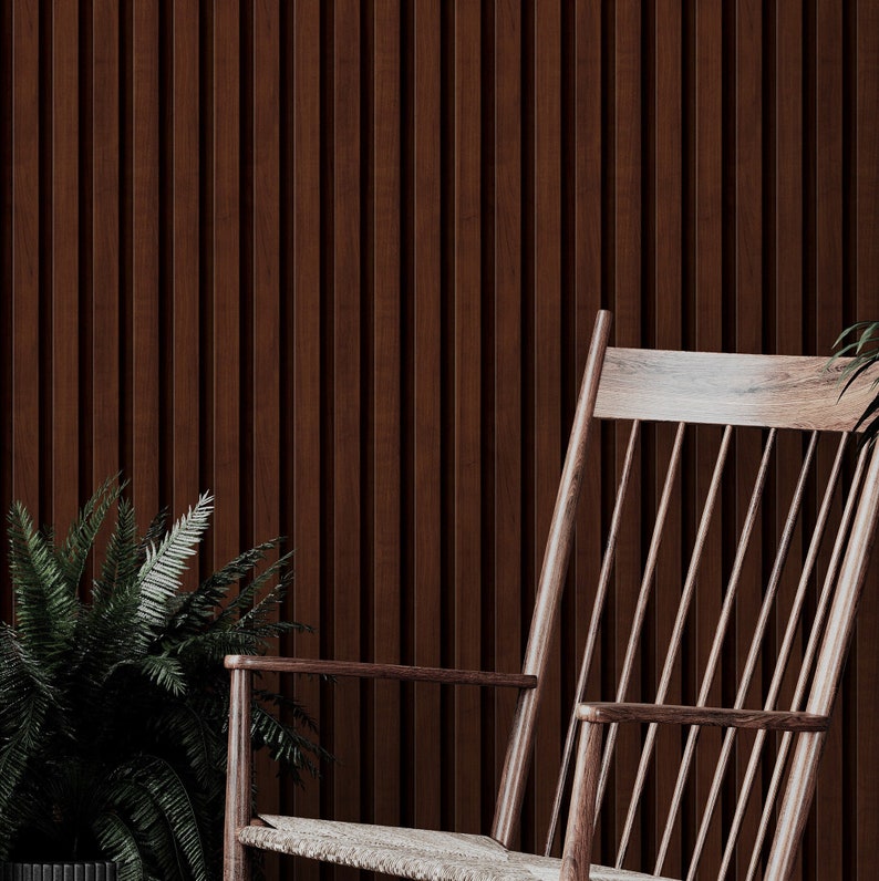May include: A wooden rocking chair with a slatted back and seat. The chair is in front of a wall with vertical wooden panels.