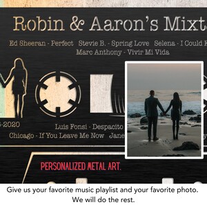 May include: A black metal cassette tape design with a photo of a couple on a beach. The cassette tape has a date, "10-05-2020", and a list of song titles and artists, including "Ed Sheeran - Perfect", "Stevie B. - Spring Love", "Selena - I Could Fall In Love", "Marc Anthony - Vivir Mi Vida", "Luis Fonsi - Despacito", and "Chicago - If You Leave Me Now". The text "Robin & Aaron's Mixtape" is at the top of the design. The text "PERSONALIZED METAL ART." is at the bottom of the design.