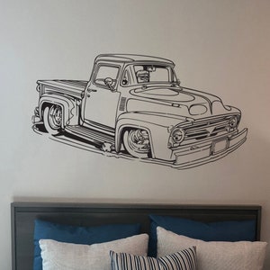 May include: Black and white line art illustration of a vintage pickup truck. The truck has a large grill and a single cab. The truck is facing the viewer and is slightly angled to the left.
