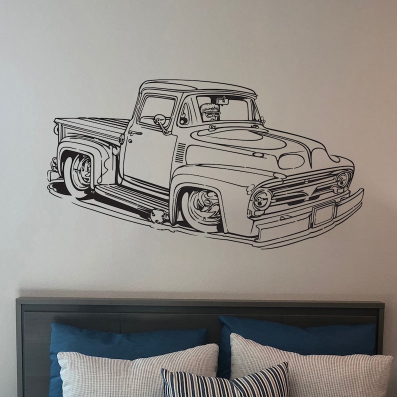 May include: Black and white line art illustration of a vintage pickup truck. The truck has a large grill and a single cab. The truck is facing the viewer and is slightly angled to the left.
