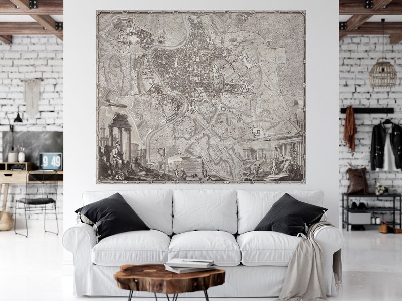 May include: A vintage black and white map of Rome, Italy, with detailed streets and landmarks. The map is framed and hanging on a white wall in a modern living room.