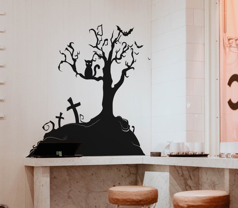 May include: Black and white silhouette wall decal of a spooky tree with a cat, bats, and tombstones. The decal is on a white wall above a marble countertop.