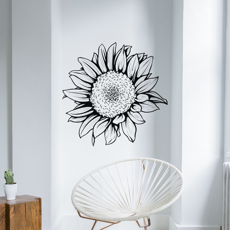 Puede incluir: Ilustraci&oacute;n en blanco y negro de una l&iacute;nea de arte de un girasol. El girasol est&aacute; mirando hacia el lado derecho de la imagen. El girasol est&aacute; en una pared blanca.