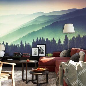 May include: A wall mural featuring a panoramic view of layered mountain ranges and a dense pine forest in shades of green and blue. The scene transitions from a dark foreground to a hazy, light-filled horizon under a soft, gradient sky.