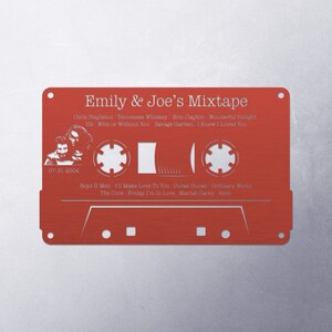 May include: A red cassette tape with a white outline and the text "Emily & Joe's Mixtape" printed on it. The cassette tape has a list of songs and artists printed on it, including Chris Stapleton, Eric Clapton, Savage Garden, Boyz II Men, Duran Duran, The Cure, and Mariah Carey.