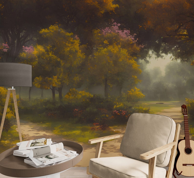 Pode incluir: Um interior de sala com um candeeiro de p&eacute; cinzento, uma mesa de centro redonda castanha com revistas empilhadas, uma poltrona clara com apoios de bra&ccedil;os em madeira e uma guitarra ac&uacute;stica, contra um mural de floresta enevoada com &aacute;rvores amarelas.